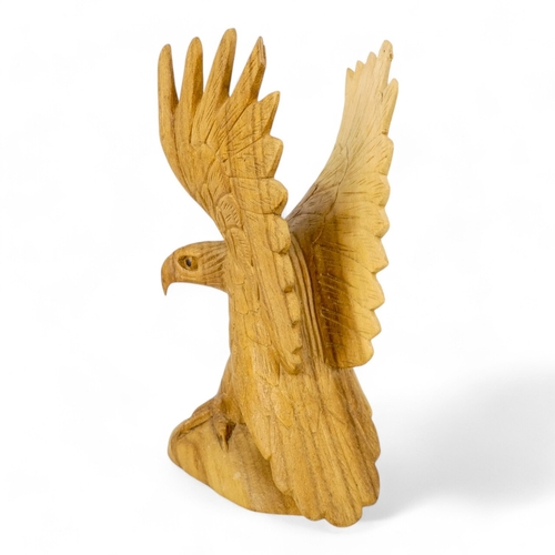 125 - A 20th century carved hardwood eagle - wings outstretched, 30cm high.