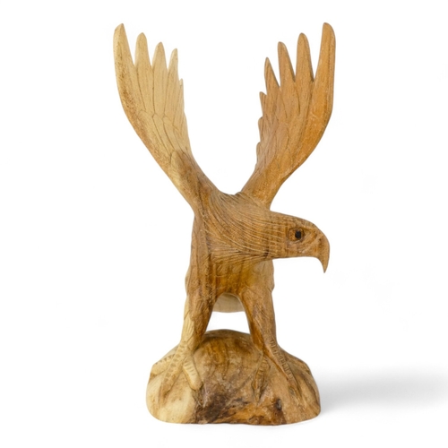 125 - A 20th century carved hardwood eagle - wings outstretched, 30cm high.