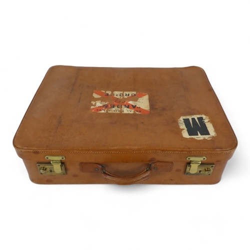 134 - A mid 20th century set of tan leather luggage - two large and one smaller, with brass catches and ta... 