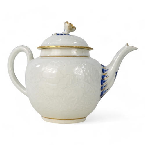 202 - A late 18th century bullet shaped teapot - with moulded floral and foliate decoration with blue and ... 