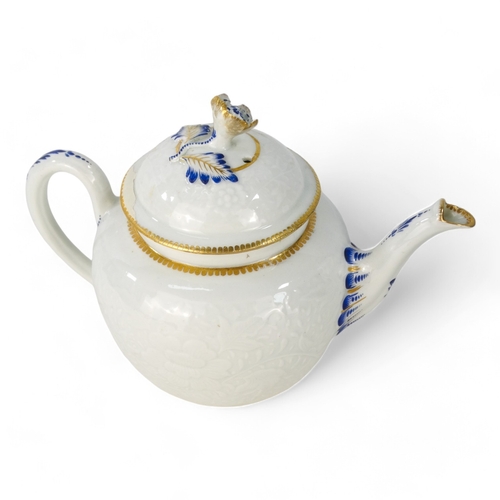 202 - A late 18th century bullet shaped teapot - with moulded floral and foliate decoration with blue and ... 