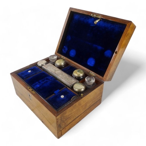 22 - A late Victorian walnut dressing case - the blue velvet fitted interior with glass and silverplated ... 