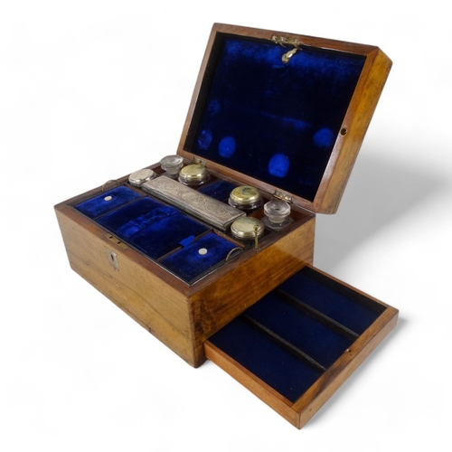 22 - A late Victorian walnut dressing case - the blue velvet fitted interior with glass and silverplated ... 