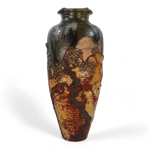 223 - A large early 20th century baluster shaped vase - with an oriental design in low relief and with gre... 