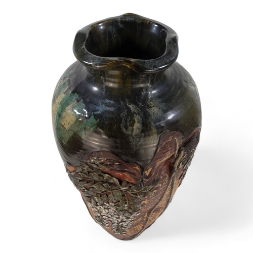 223 - A large early 20th century baluster shaped vase - with an oriental design in low relief and with gre... 