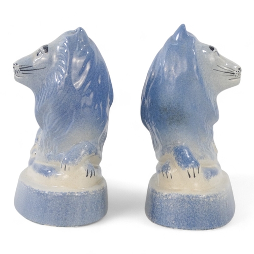 224 - A pair of Rye Pottery lions - recumbent, with a blue sponged finish, 18cm wide. (2)