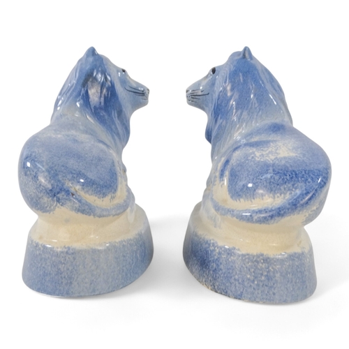 224 - A pair of Rye Pottery lions - recumbent, with a blue sponged finish, 18cm wide. (2)