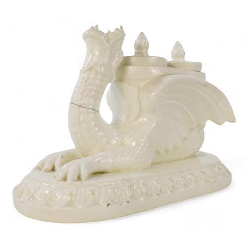 236 - A 19th century creamware ink stand - modelled as a dragon with twin lidded pots and raised on an ova... 