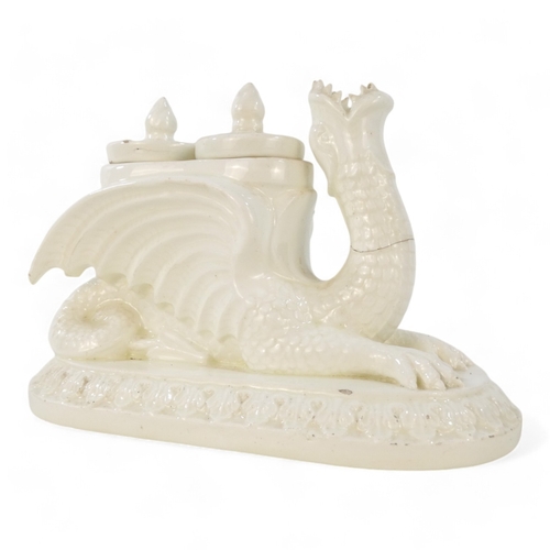 236 - A 19th century creamware ink stand - modelled as a dragon with twin lidded pots and raised on an ova... 