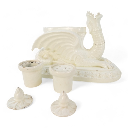 236 - A 19th century creamware ink stand - modelled as a dragon with twin lidded pots and raised on an ova... 