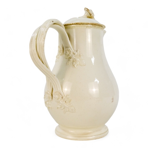 243 - A late 18th century creamware jug - of lidded baluster form, the wrythen handles with floral termina... 