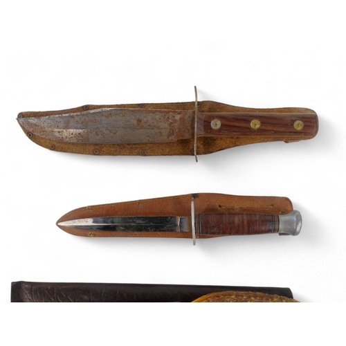 25 - A 20th century Bowie knife - Solingen Germany, with a walnut handle, within a brown leather scabbard... 