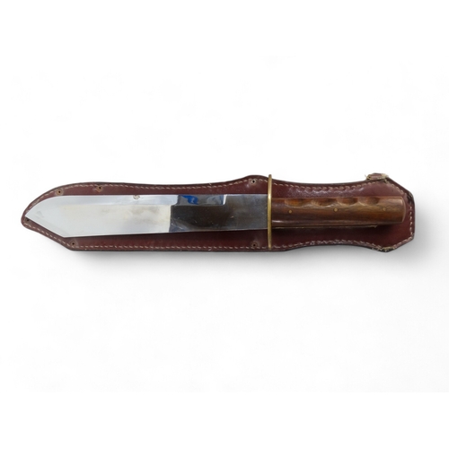 25 - A 20th century Bowie knife - Solingen Germany, with a walnut handle, within a brown leather scabbard... 