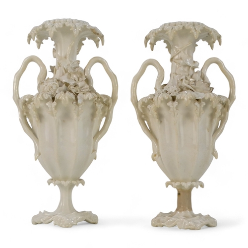 255 - A pair of late 19th century Blanc de chine vases - of fluted baluster form and encrusted with flower... 