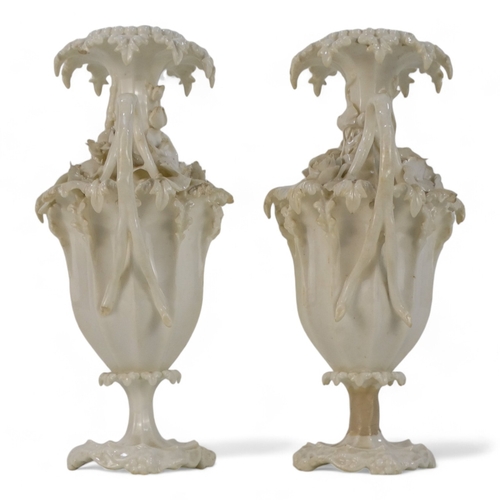 255 - A pair of late 19th century Blanc de chine vases - of fluted baluster form and encrusted with flower... 