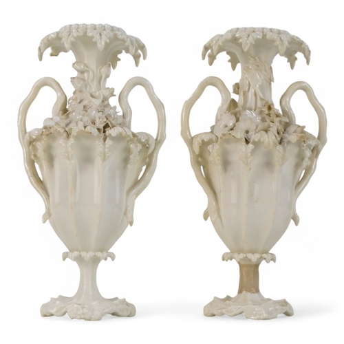 255 - A pair of late 19th century Blanc de chine vases - of fluted baluster form and encrusted with flower... 