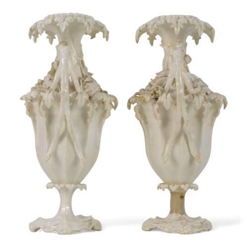 255 - A pair of late 19th century Blanc de chine vases - of fluted baluster form and encrusted with flower... 