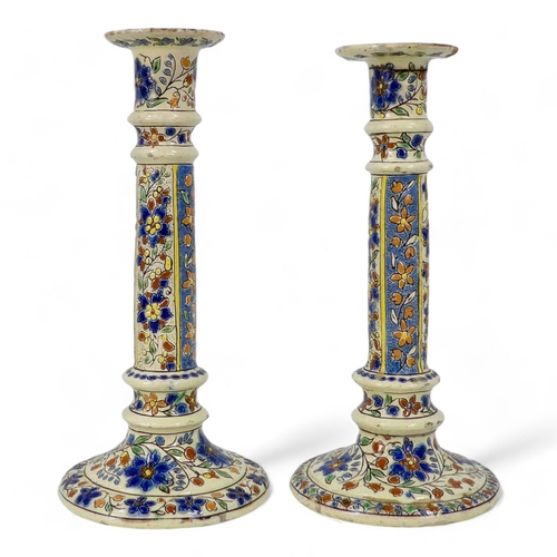 271 - A pair of early 20th century Iznik style candlesticks - decorated with trailing flowers on a cream g... 