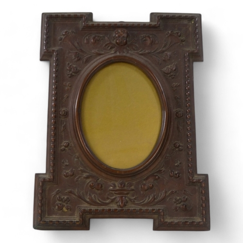 32 - A late 19th century copper photograph frame - rectangular with an oval aperture, repousse decorated ... 