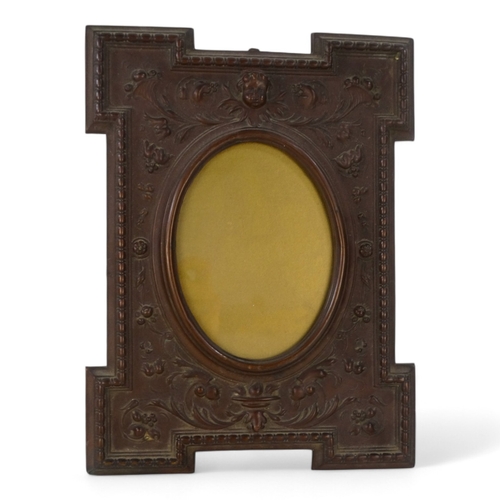 32 - A late 19th century copper photograph frame - rectangular with an oval aperture, repousse decorated ... 