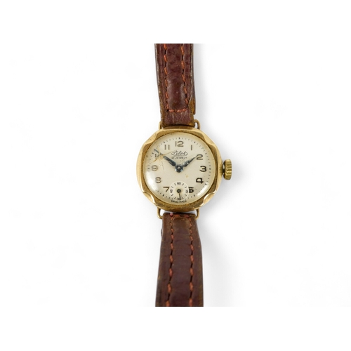 706 - A 9ct gold ladies wristwatch - the silvered dial set out in Arabic numerals, on a leather strap.