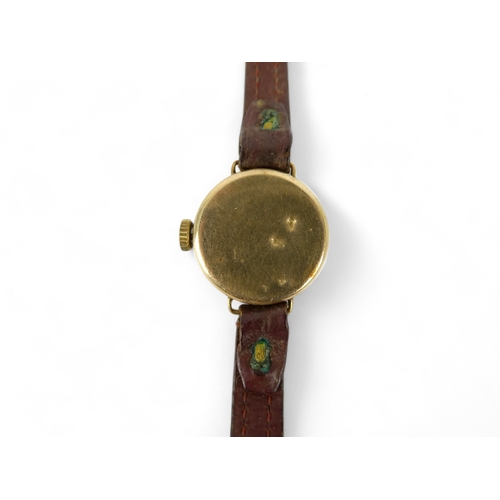 706 - A 9ct gold ladies wristwatch - the silvered dial set out in Arabic numerals, on a leather strap.