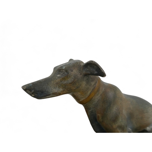 73 - An Art Deco spelter dog group - the pair of hounds raised on a polished marble base, 52cm wide.