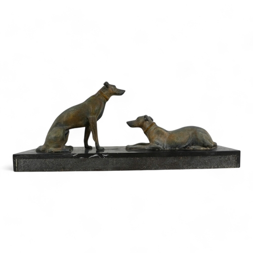 73 - An Art Deco spelter dog group - the pair of hounds raised on a polished marble base, 52cm wide.