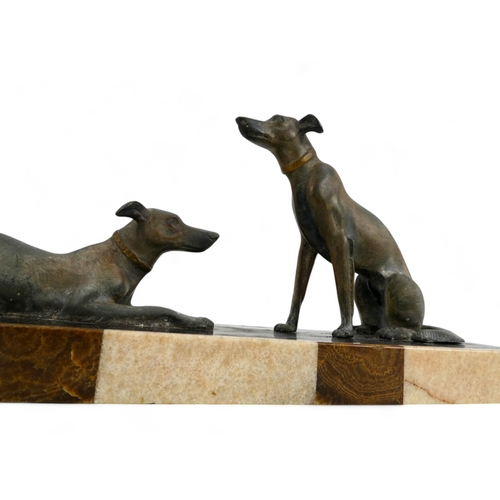 73 - An Art Deco spelter dog group - the pair of hounds raised on a polished marble base, 52cm wide.