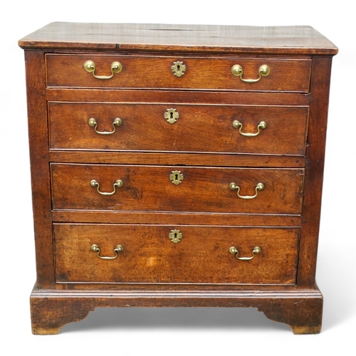 951 - A late George II oak chest of drawers - with an arrangement of four graduated drawers and panelled s... 