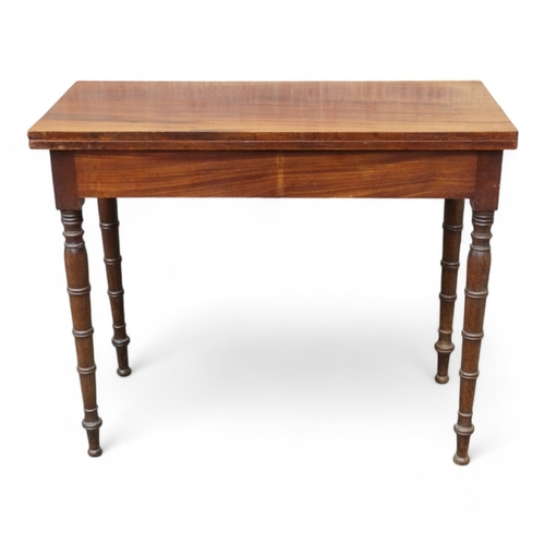 953 - A George IV mahogany tea table - the rectangular top on a swivelling frame on turned tapering legs, ... 