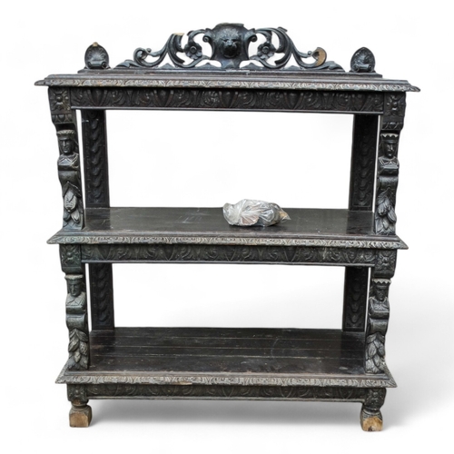 954 - A 17th century style oak buffet - with a pierced and carved raised back above three rectangular tier... 