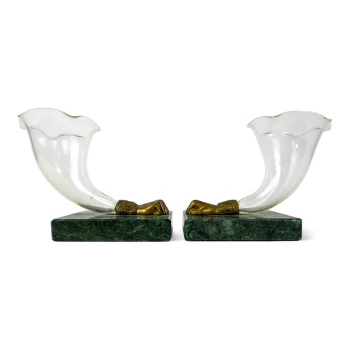 98 - A pair of glass and marble cornucopia - clear glass terminating in a brass fist, raised on a green m... 