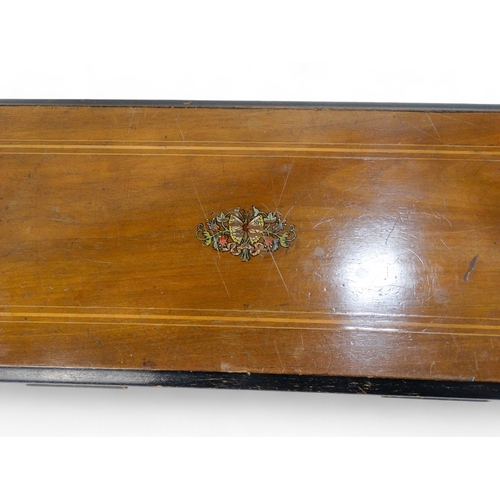 16 - A late 19th century cylinder music box - the rectangular walnut case with stringing and stencilled d... 