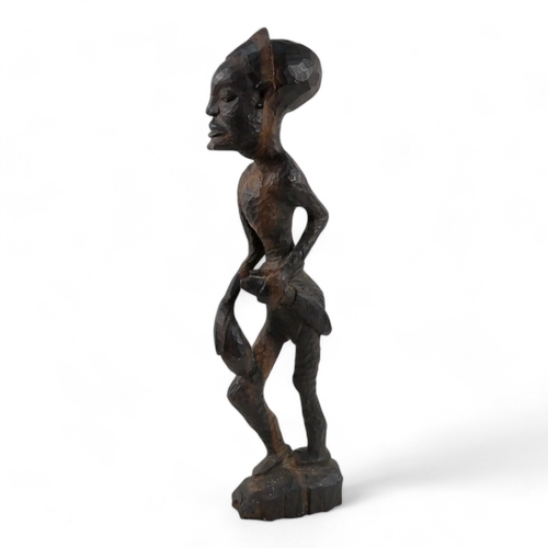 17 - A 20th century carved figure of an African warrior - 65cm high, together with four carved hardwood A... 