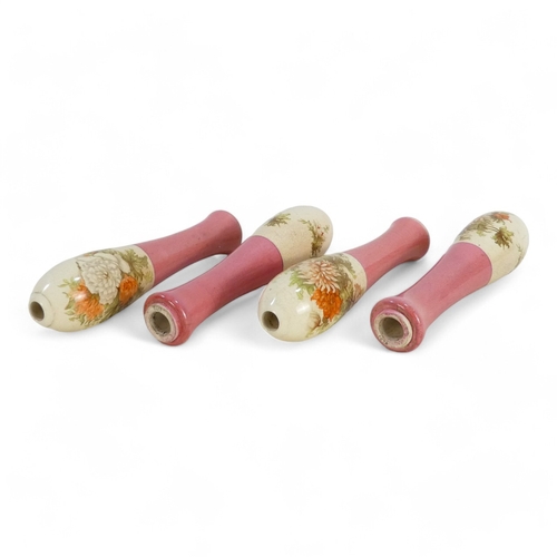 229 - Four early 20th century ceramic beer pump handles - of typical baluster form, pink and white with fl... 