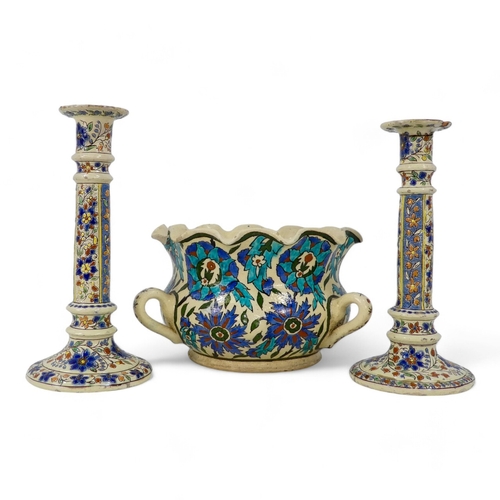 236 - A pair of early 20th century Iznik style candlesticks - decorated with trailing flowers on a cream g... 