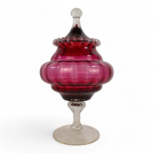 266 - An Empoli style cranberry vase and cover - of circular ribbed form and raised on a pedestal foot, 33... 