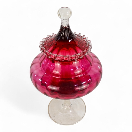 266 - An Empoli style cranberry vase and cover - of circular ribbed form and raised on a pedestal foot, 33... 