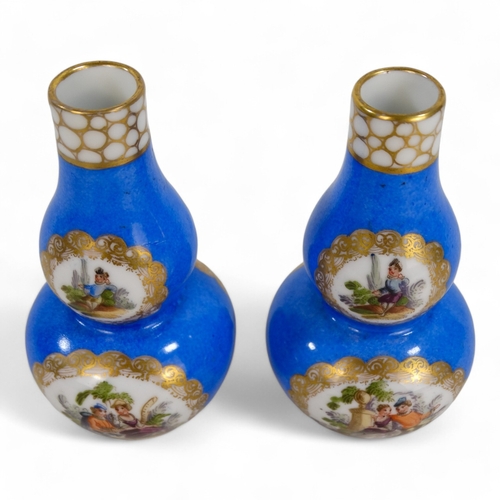 269 - A pair of German double gourd vases - gilt decorated with vignettes of country scenes, crossed ploug... 