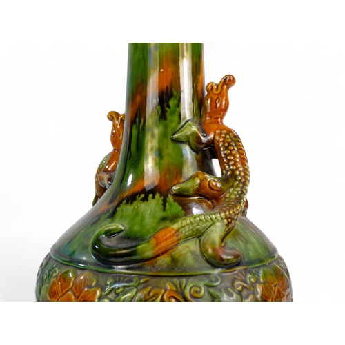 272 - A late 19th century bottle shaped vase - green and treacle glaze, with an impressed foliate band and... 