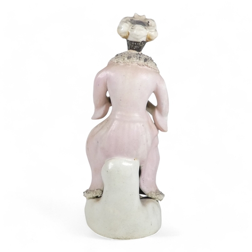 279 - A 19th century Staffordshire figure of a Turk - wearing a long pink jacket, 21cm high.