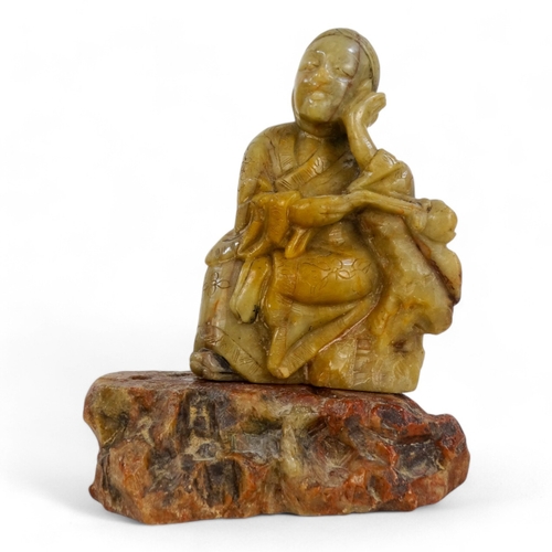 314A - An 20th century carved hardstone figure of Guangin - seated with a flower on a rocky base, 13cm high... 