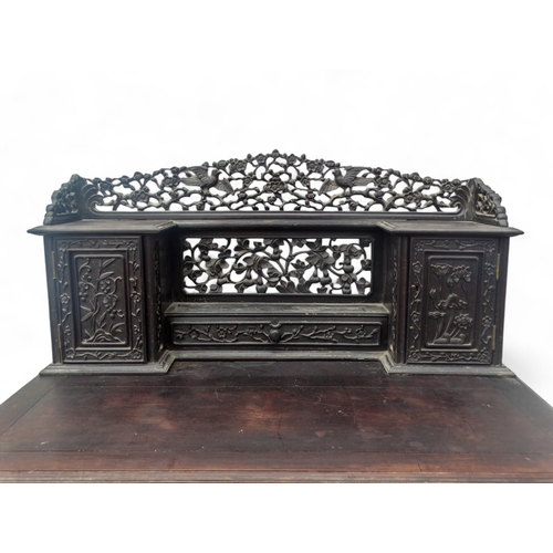 315 - An early 20th century oriental carved hardwood desk - of asymmetrical form incorporating pierced pan... 