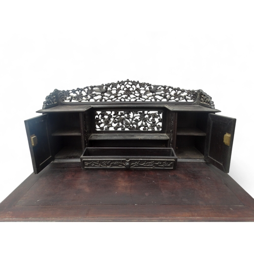 315 - An early 20th century oriental carved hardwood desk - of asymmetrical form incorporating pierced pan... 