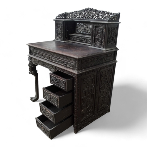 315 - An early 20th century oriental carved hardwood desk - of asymmetrical form incorporating pierced pan... 