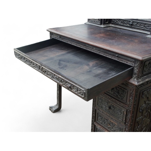 315 - An early 20th century oriental carved hardwood desk - of asymmetrical form incorporating pierced pan... 