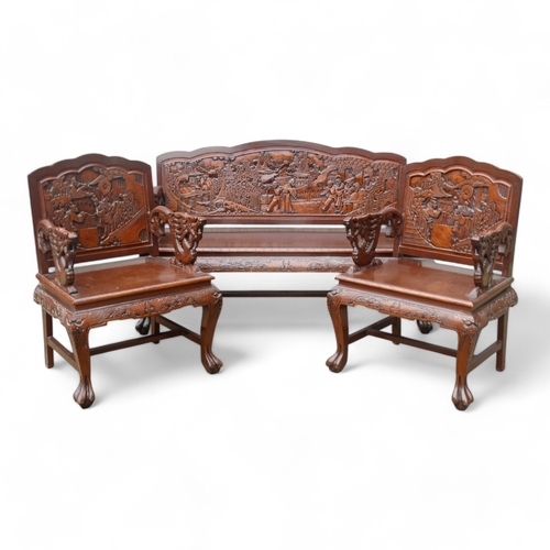 318 - A late 20th century Chinese carved hardwood two seat sofa - the back carved with figures in an exoti... 