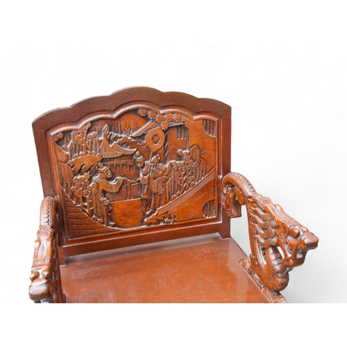 318 - A late 20th century Chinese carved hardwood two seat sofa - the back carved with figures in an exoti... 