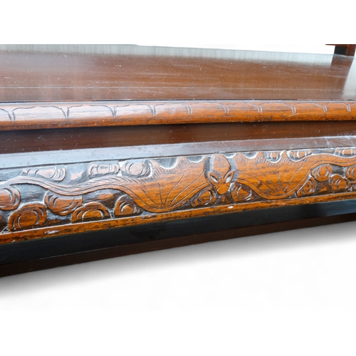 318 - A late 20th century Chinese carved hardwood two seat sofa - the back carved with figures in an exoti... 